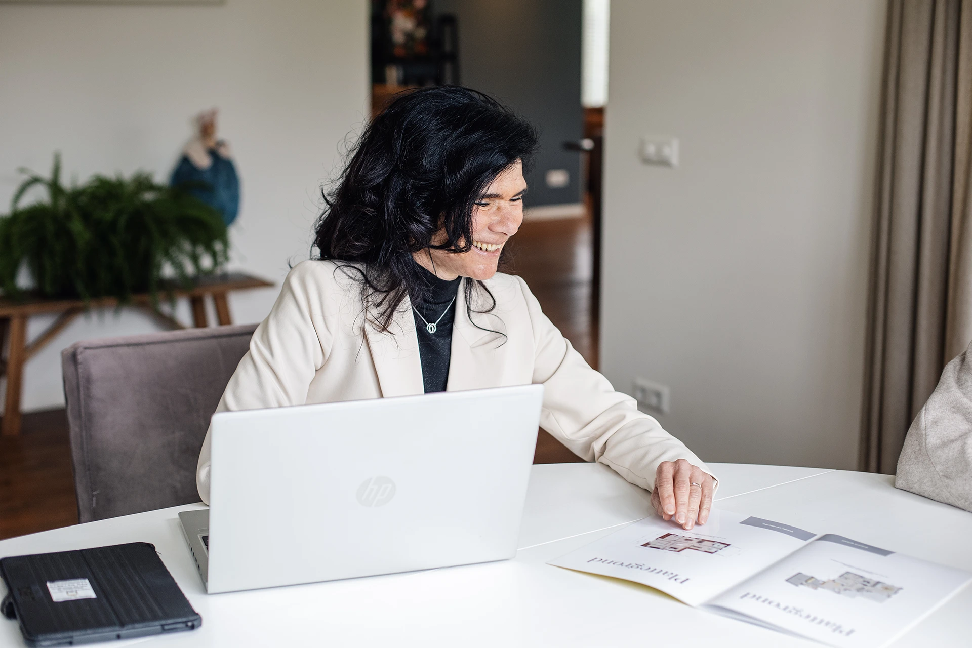 Mona neemt een brochure door van een koopwoning in Breda